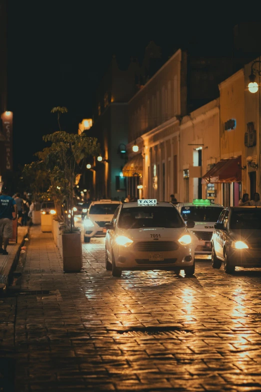 cars parked on a wet city street at night