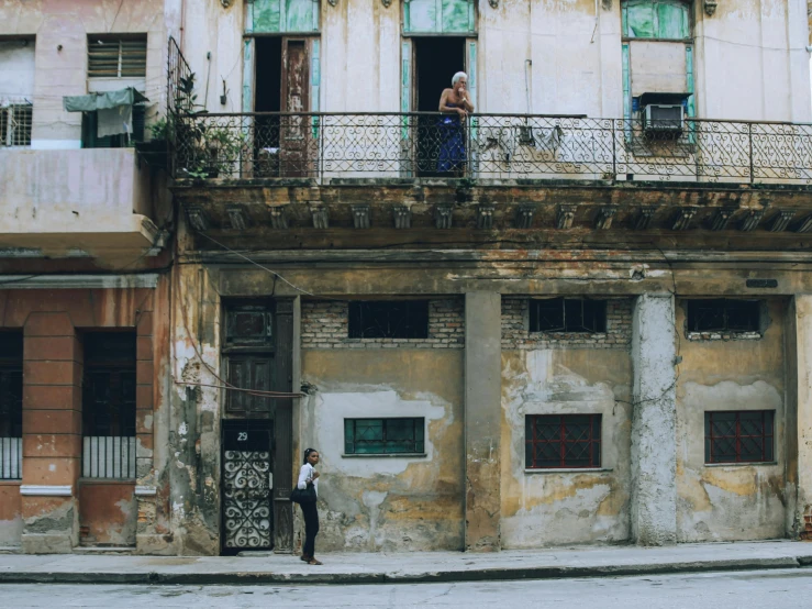 people standing outside of a dirty building