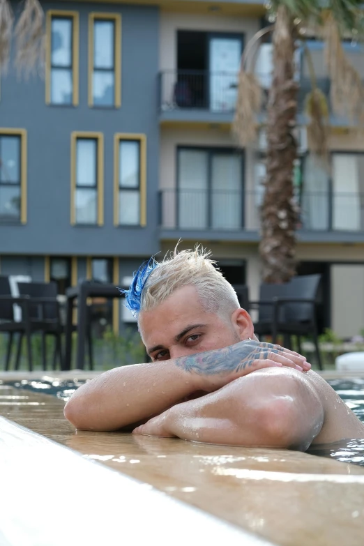 a man with blonde hair standing in a pool