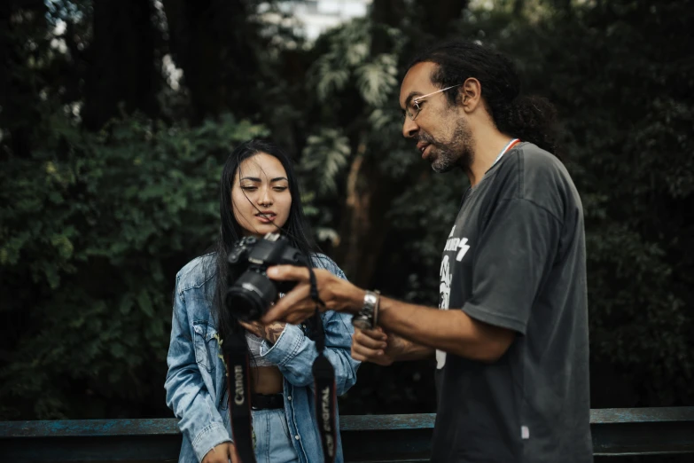 a woman with long hair looking at her camera being pographed by two males