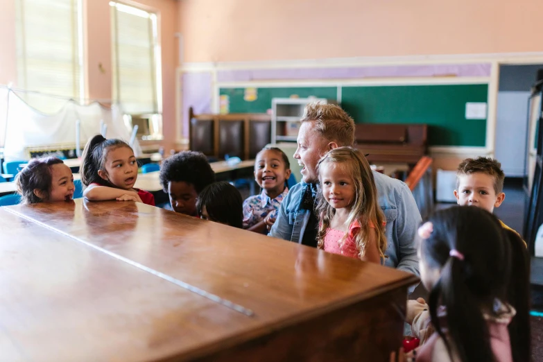 children standing at the edge of an old wooden counter