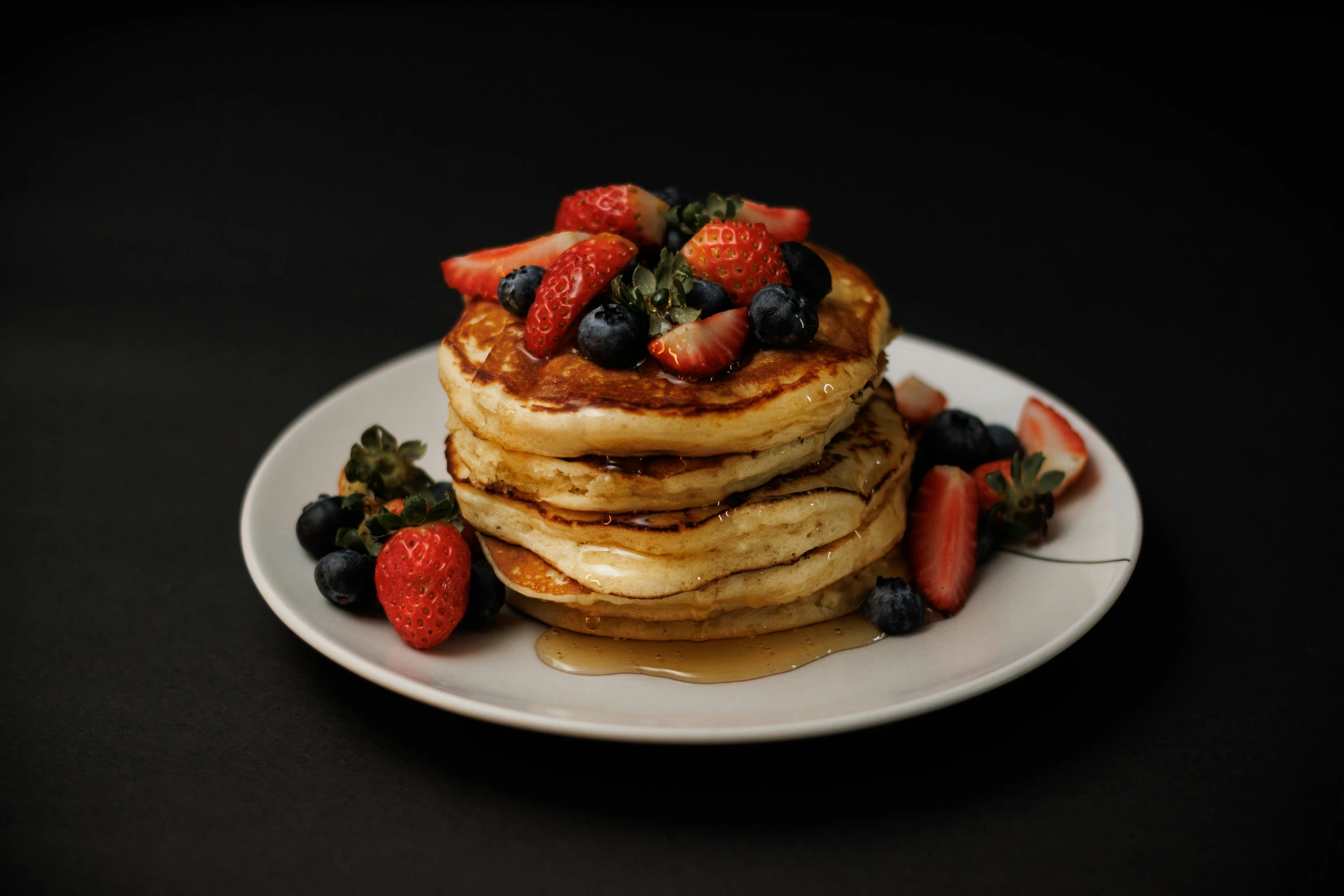 a pile of pancakes with fruit on top of it