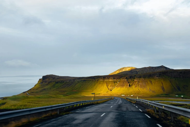 a scenic s of an open road leading towards the mountains