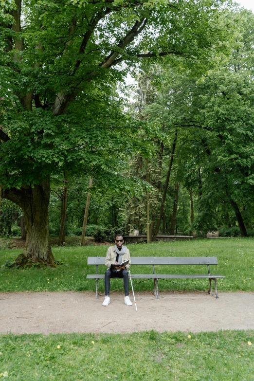 person sitting on a bench with crutches in the park
