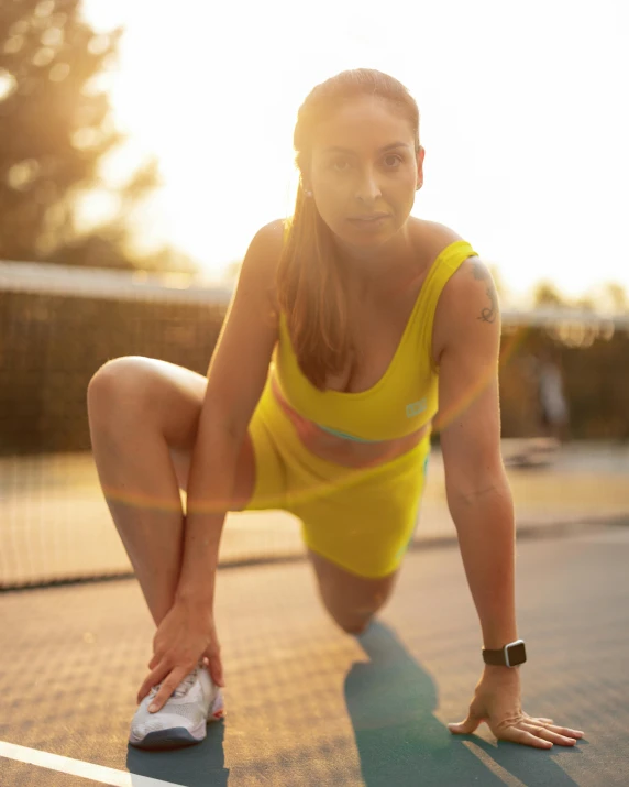 a woman leaning down in a tennis pose