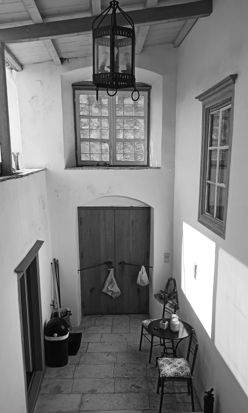 an empty room with several chairs and some lighting hanging from the ceiling