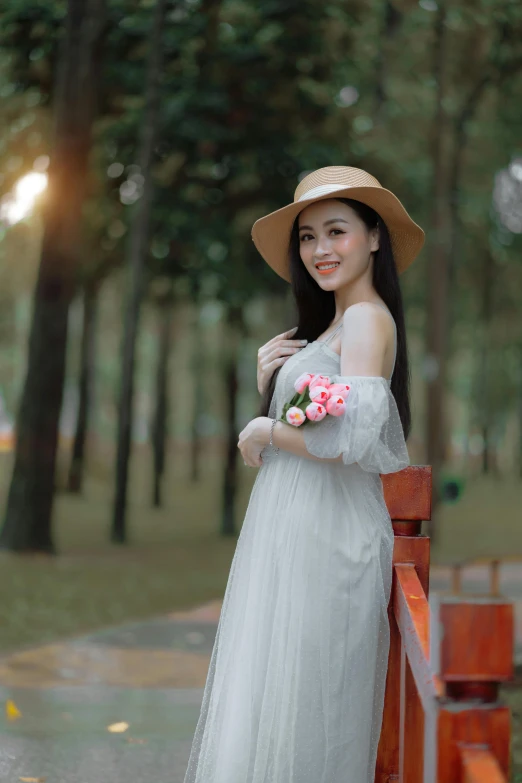 a woman is posing for a po wearing a hat and dress