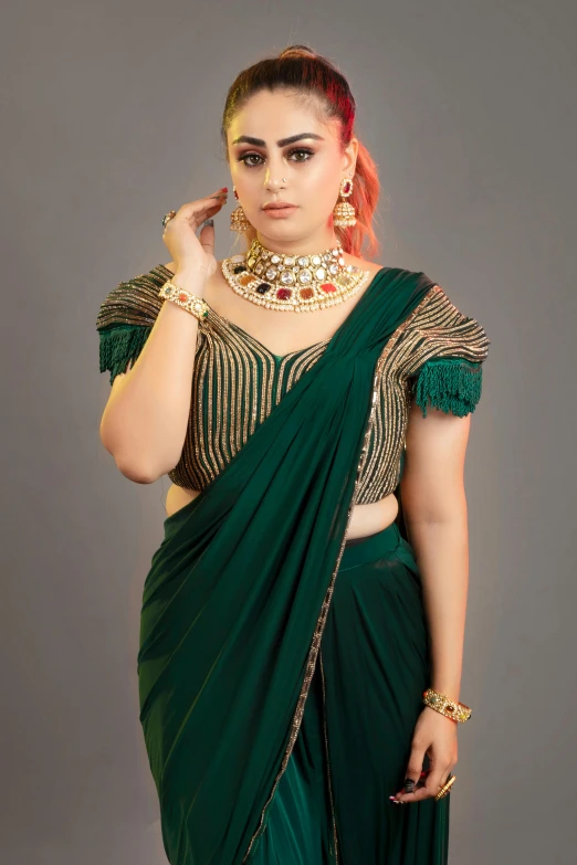 the woman in a green sari is posing