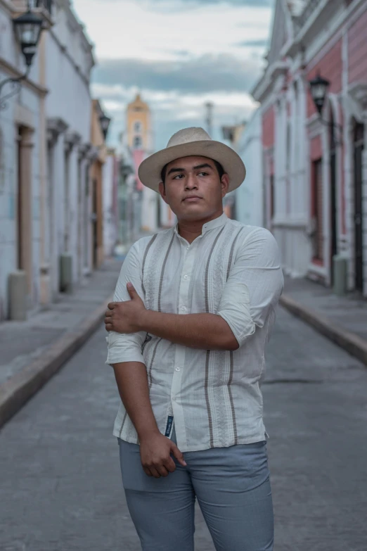 the man in a white shirt and hat is leaning against the wall