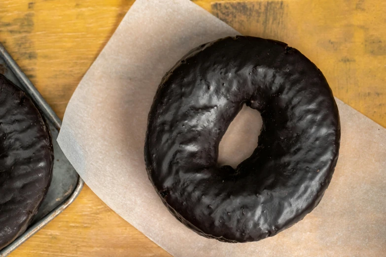 chocolate covered donuts sitting on top of a piece of paper