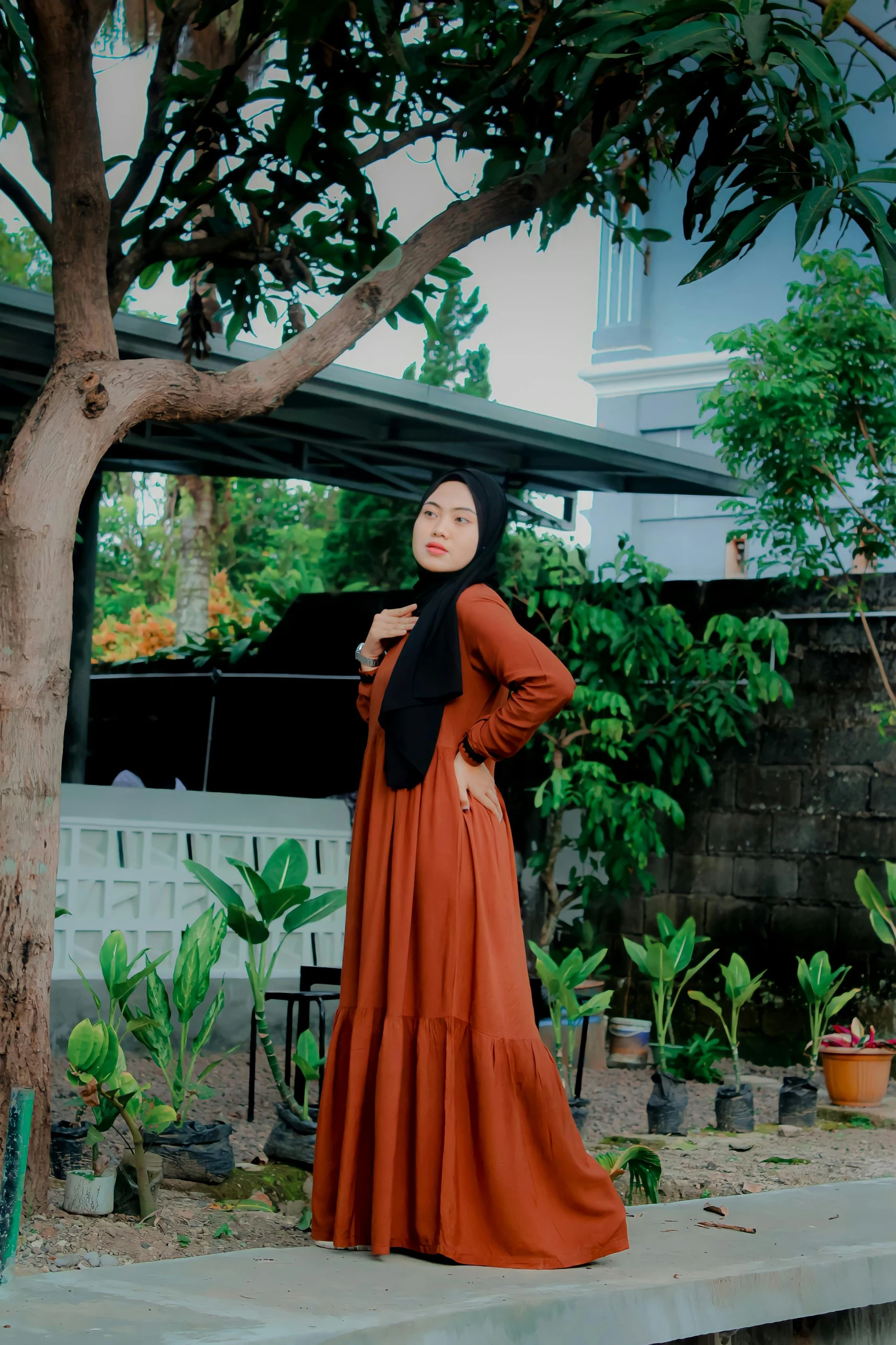 woman in long brown dress by a tree