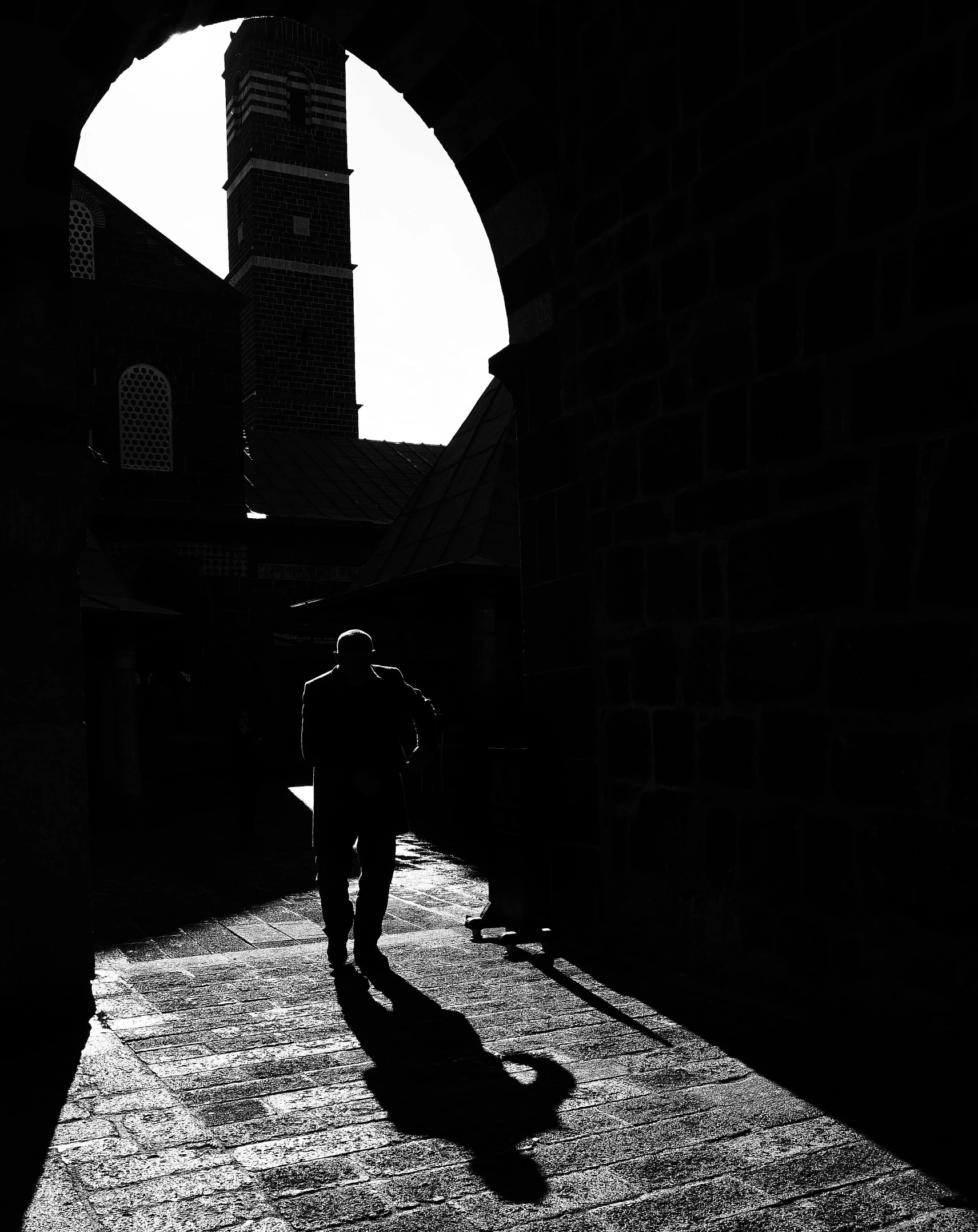 a black and white po of a person walking with an umbrella