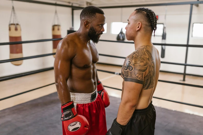 two men in a boxing ring with their tattoos on