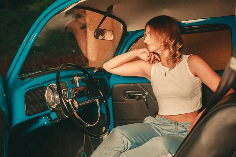 woman sitting inside a small blue pickup truck