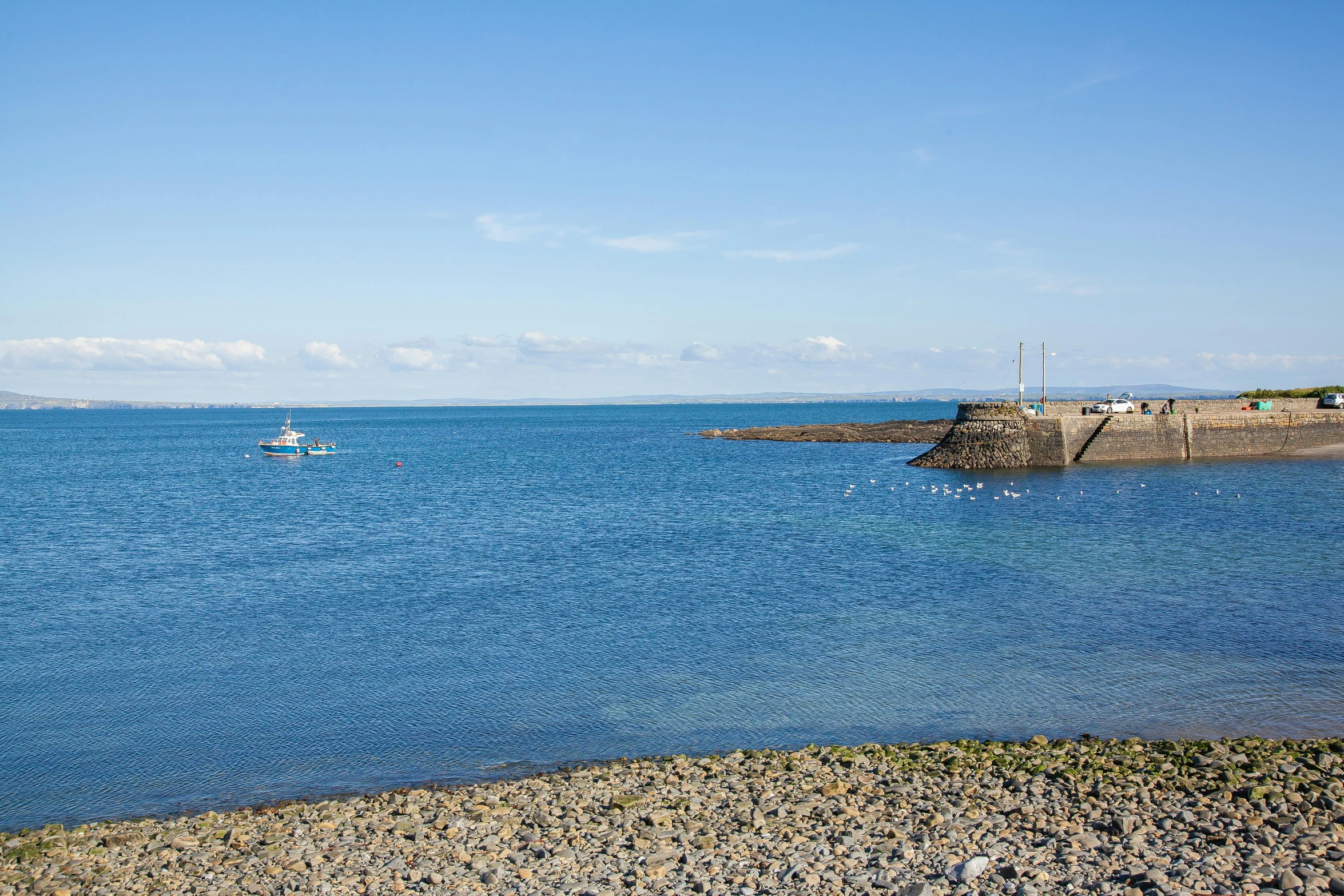 a calm ocean with some boats out to sea