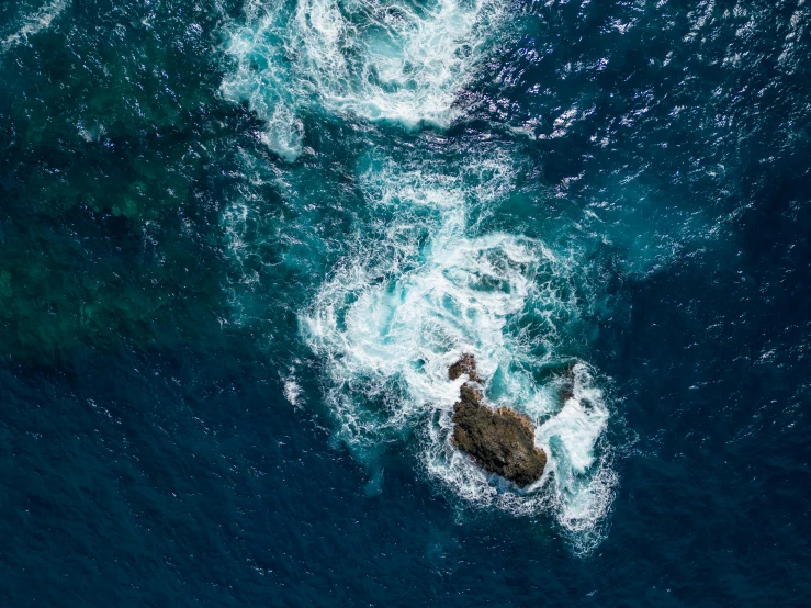 a large rock in a body of water