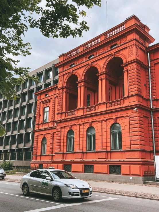 the orange building has a car parked next to it