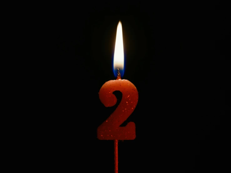 a red candle is lit with a small amount of light