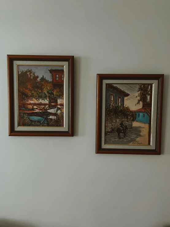 two paintings hanging on the wall above a bathtub