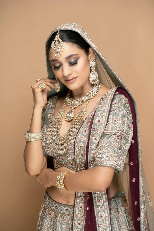 a woman dressed in indian garb standing with her hand in her pockets