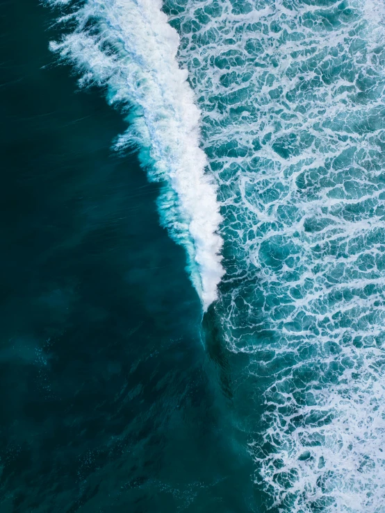 a wave breaking as it crashes through the water