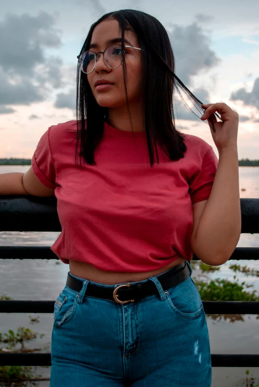 a young woman with glasses standing with a cellphone