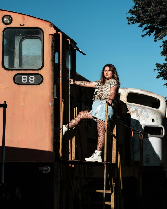 woman standing on metal rail next to old train