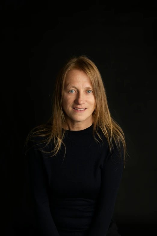 a woman with long hair and blue eyes posing for a picture