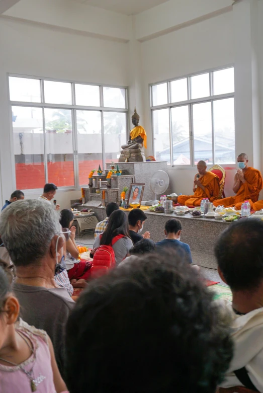 many people are at an indoor ceremony while others watch