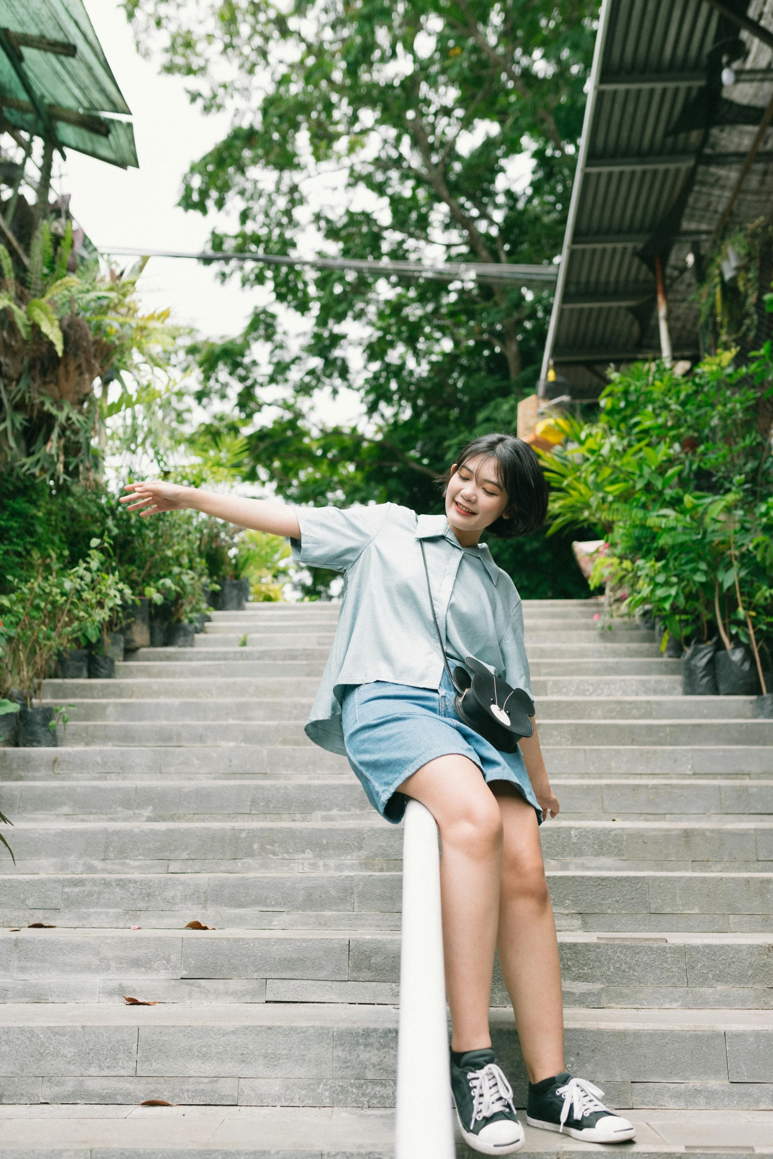 a lady with a camera leaning up against some stairs