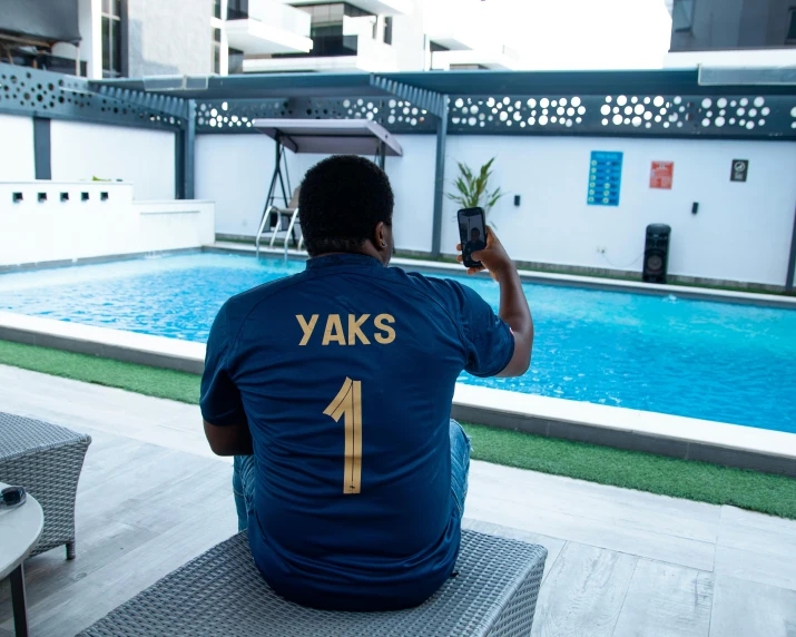 man taking picture of pool with camera at back