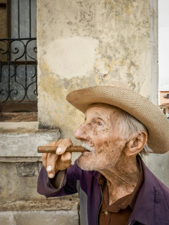 a man with a straw hat is smoking a cigar