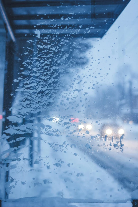 a snowy street with a traffic light and a bridge