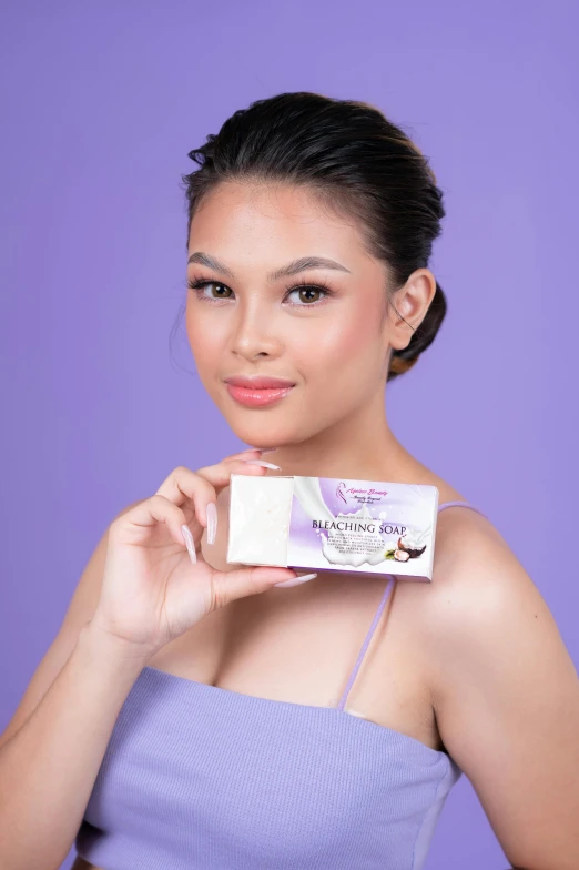 a woman in a tank top holding a bar of soap