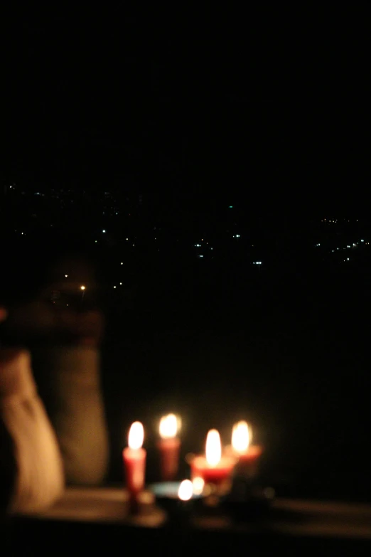 a table topped with candles on top of a black floor