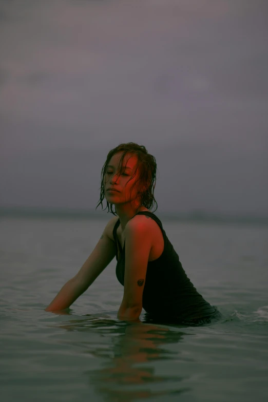 a young woman sitting on the water, with her back against the ground