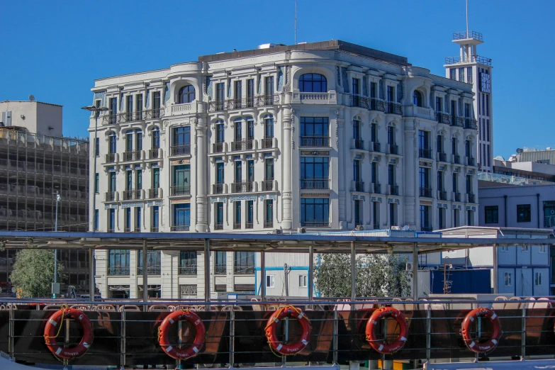 a large building next to buildings with some red hoop handles