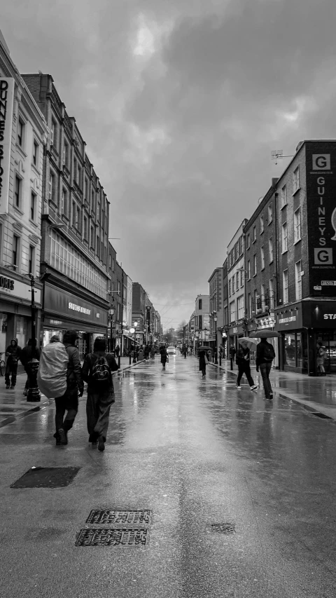 people walking on a sidewalk in the rain on a cloudy day