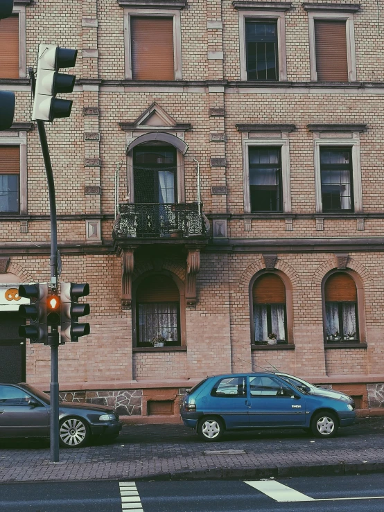 two cars are parked in front of a stone building