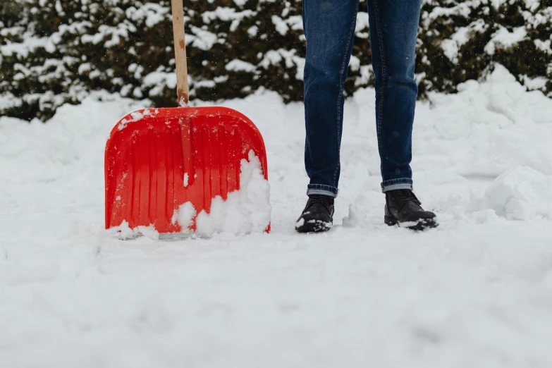 the man stands in the snow holding his suitcase