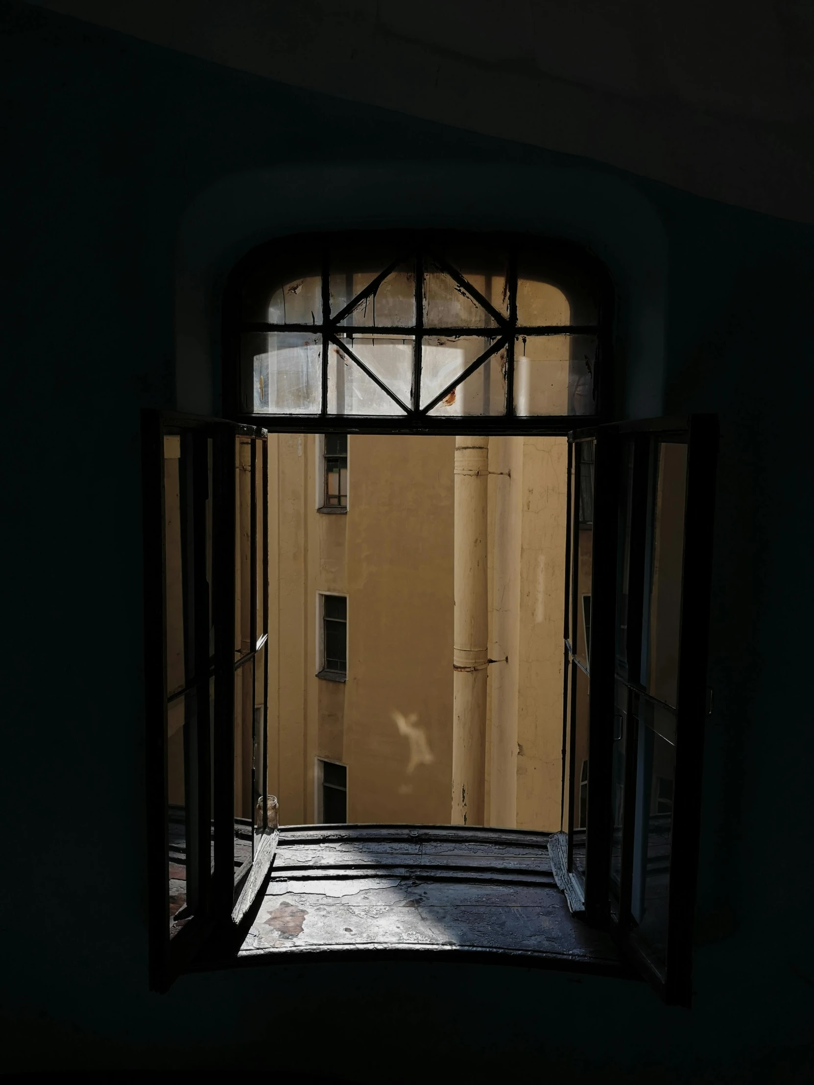 the shadow of an arch through the door shows a building