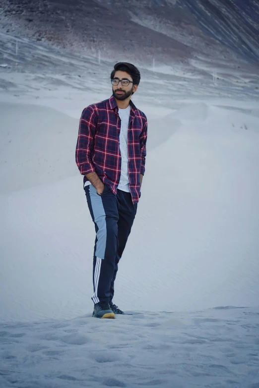 a man standing in the snow near some hills