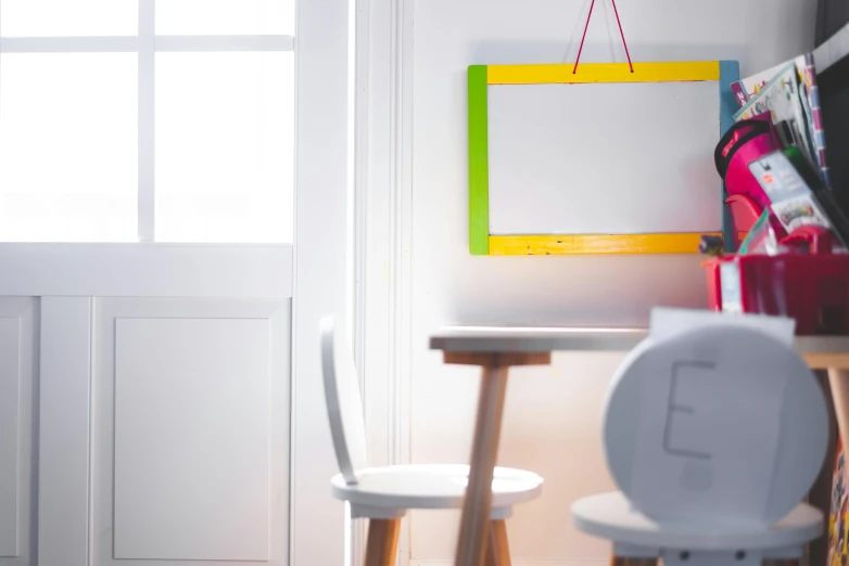 a small white desk sitting underneath a hanging sign