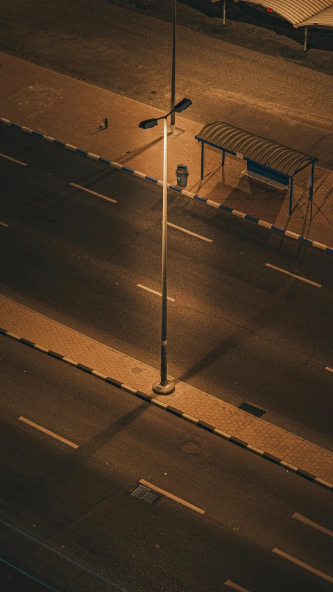 an empty parking lot with one bench in the distance