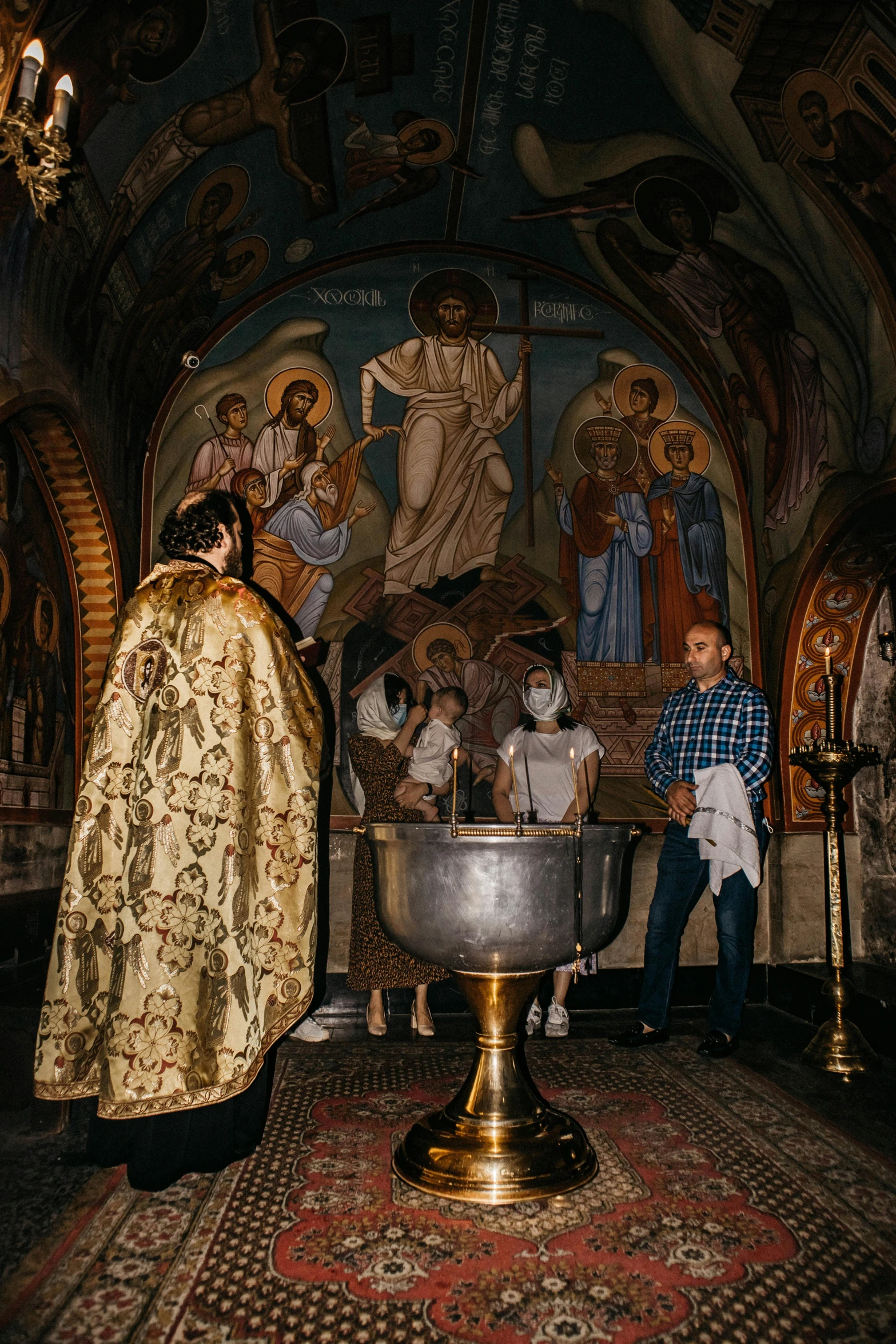 a priest and a woman kneel in front of a large church alter