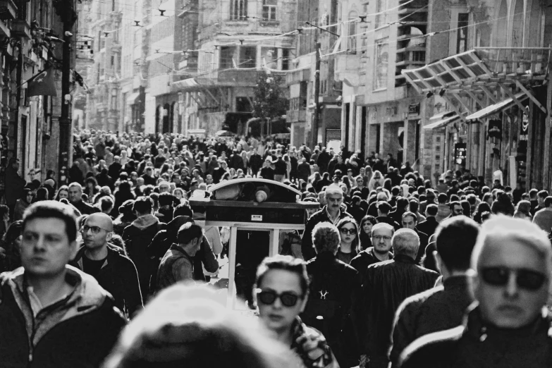 crowd of people walking down city street during daytime