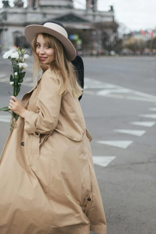 a woman walking in the street holding flowers