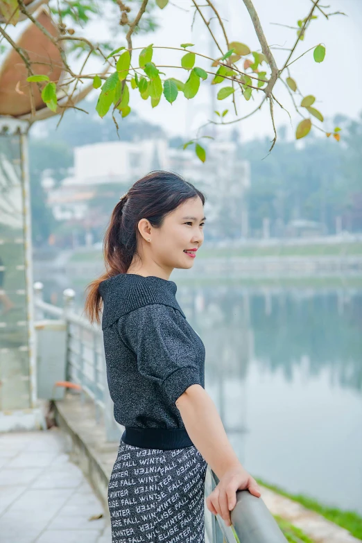 a girl standing near the water wearing a dress