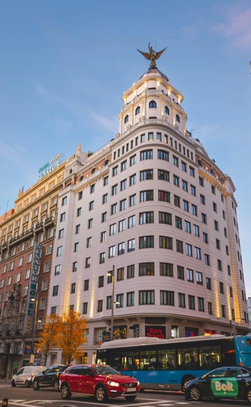 a tall building next to a busy intersection with cars passing by