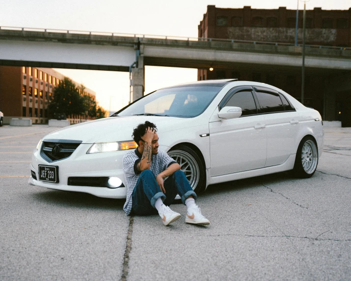 a man sits next to a parked car